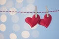 Two Red heads on the rope under clothespins on the blue background. St. ValentineÃ¢â¬â¢s Day card